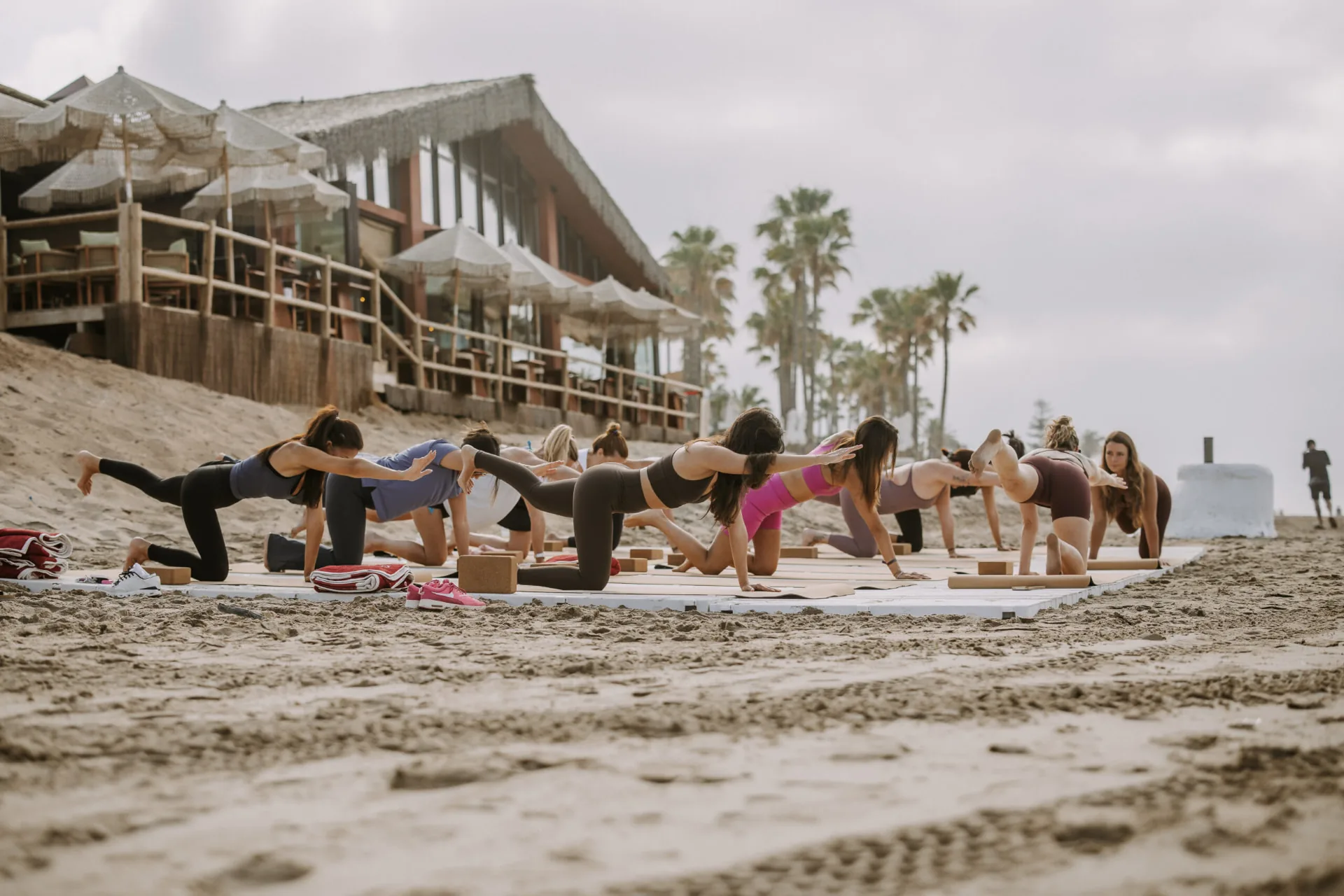Ejercicio de equilibrio en cuadrupedia durante una clase de yoga al aire libre en Marbella